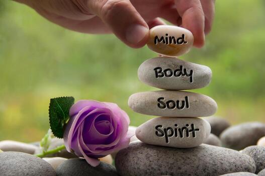 Mind Body Soul And Spirit Words Engraved On Zen Stones With Rose Flower Copy Space And Zen Concept Photo